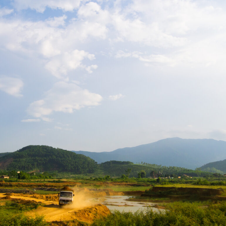 Construction truck driving over landscape in Vietnam, Asia