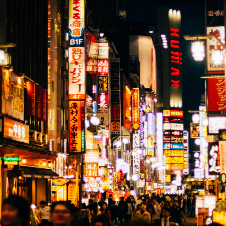 Tokyo city lights in the street at night, while people walking
