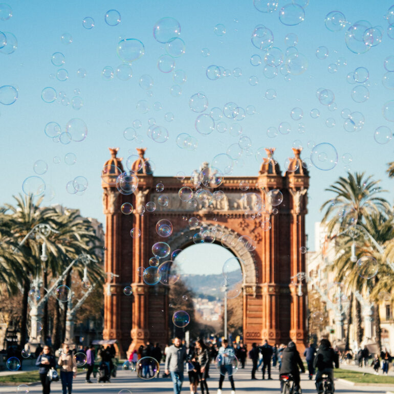 Visit Barcelona ,Spain - People walking while Soap bubbles are in the air at Arc de Triomf